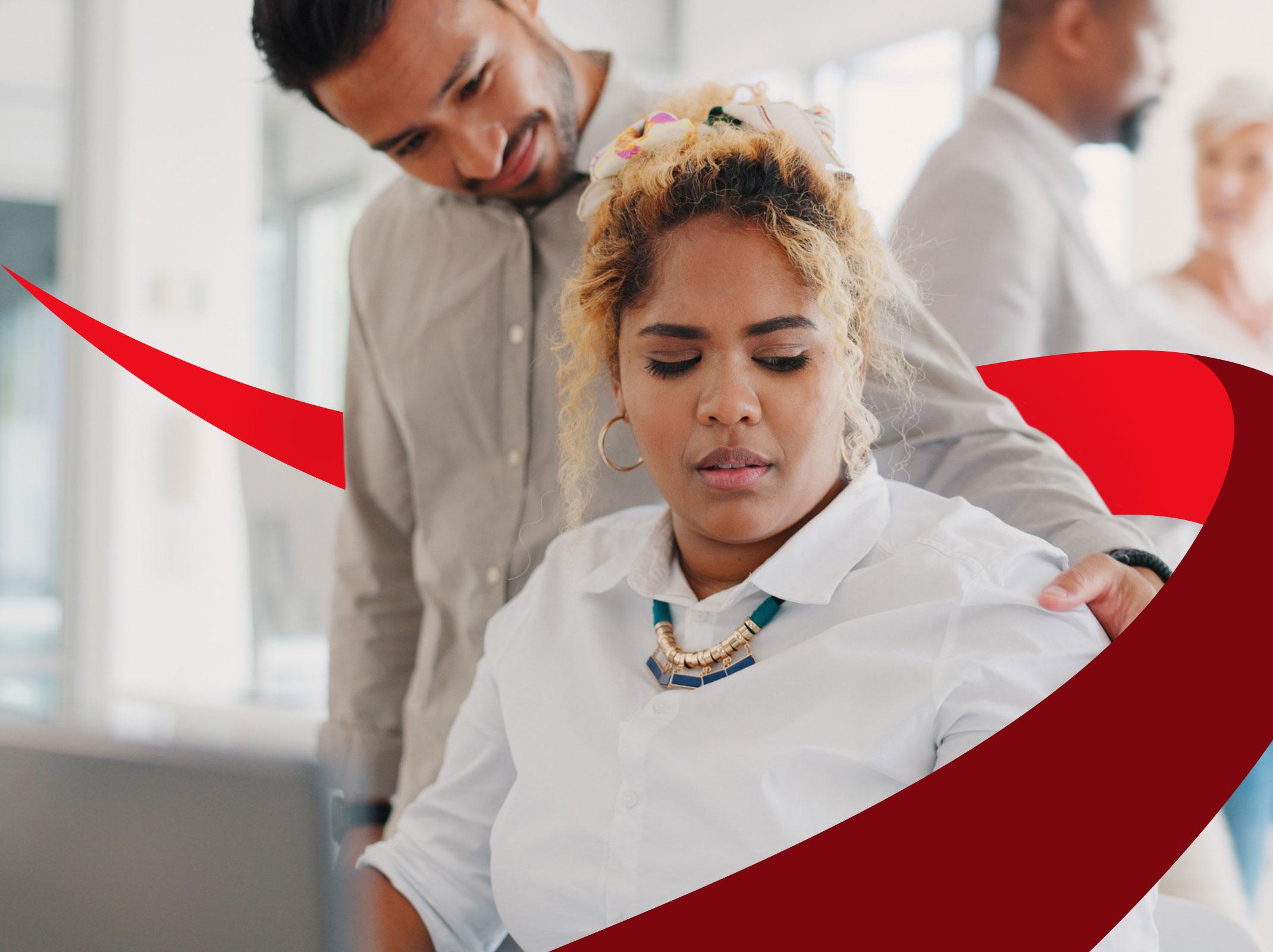 A business professional in an office setting looking uncomfortable as a coworker touches her shoulder.