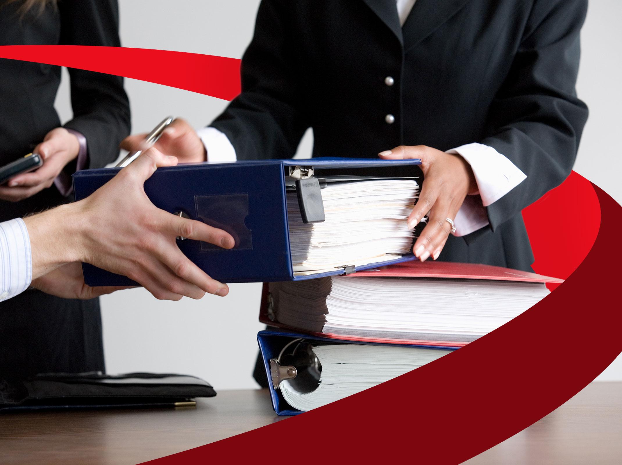 HR professionals looking through FMLA, Workers' Comp and ADA documents