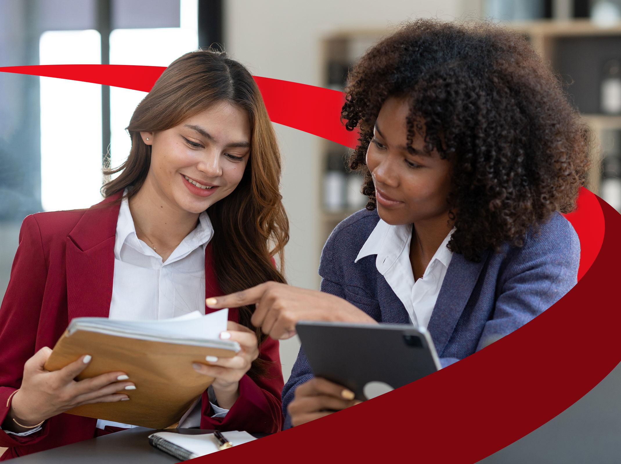 A manager providing feedback to an employee in an office setting.  She is pointing a a stack of papers that the other employee is holding.