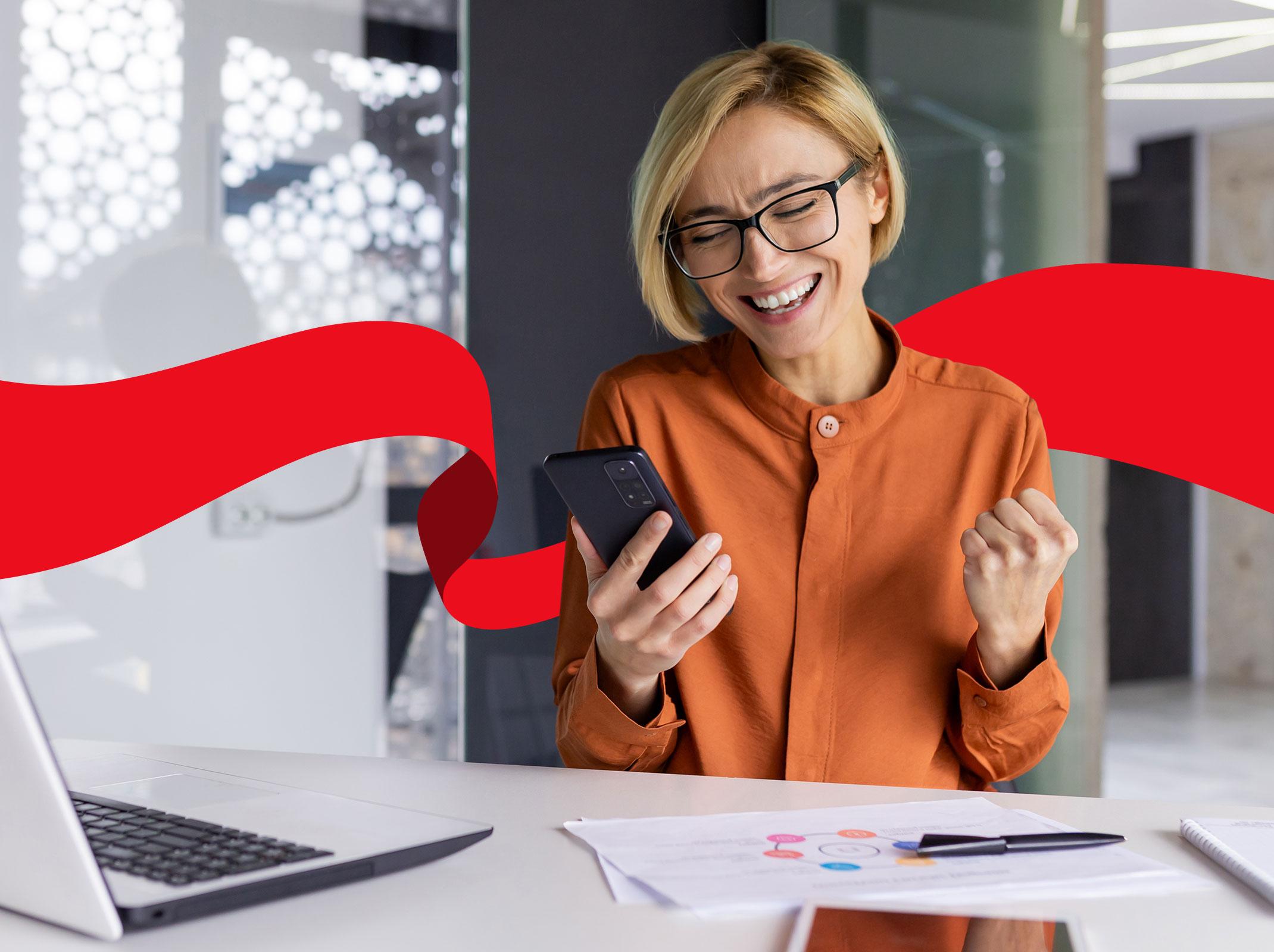 Marketing professional using a AI on laptop and phone in a business setting.