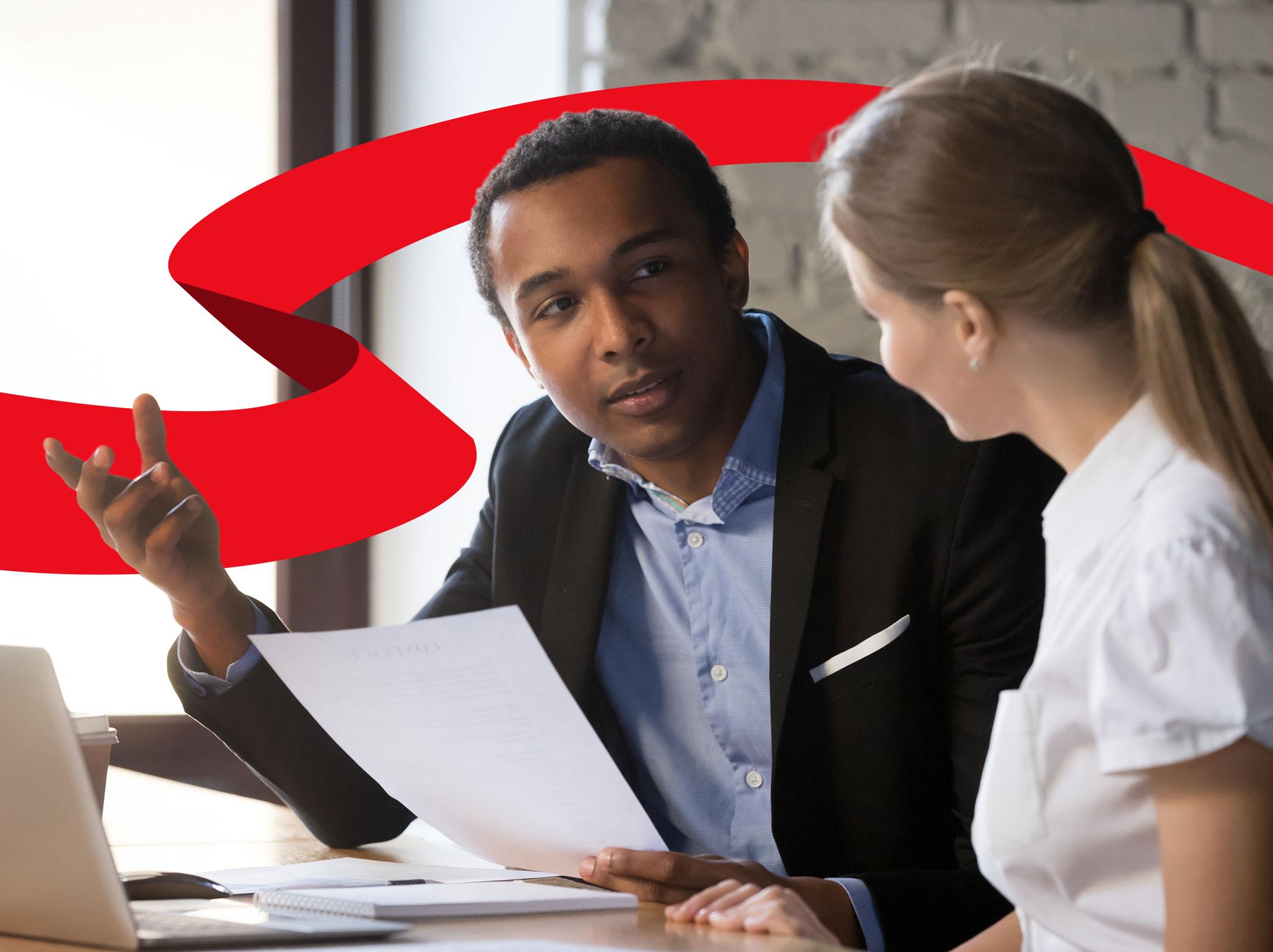 Supervisor reviewing documents with an employee in an office setting