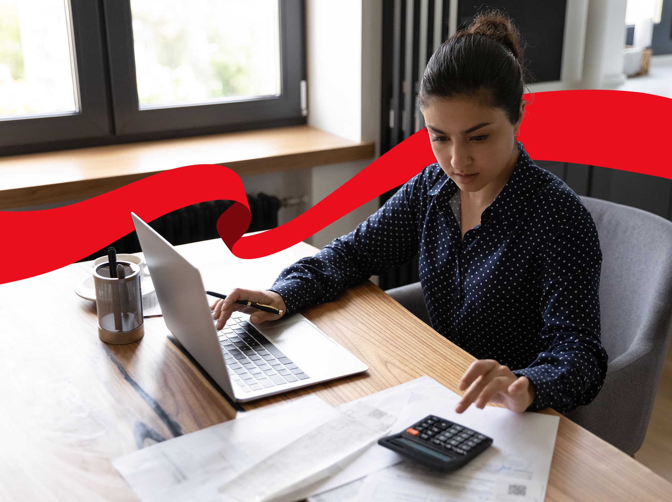 Woman using a laptop and calculator in the office